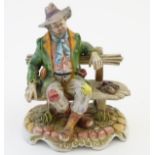 A Capodimonte figure modeled as a tramp wearing a hat on a bench.