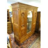 A carved three door Breton armoire with a heavily carved carcass,