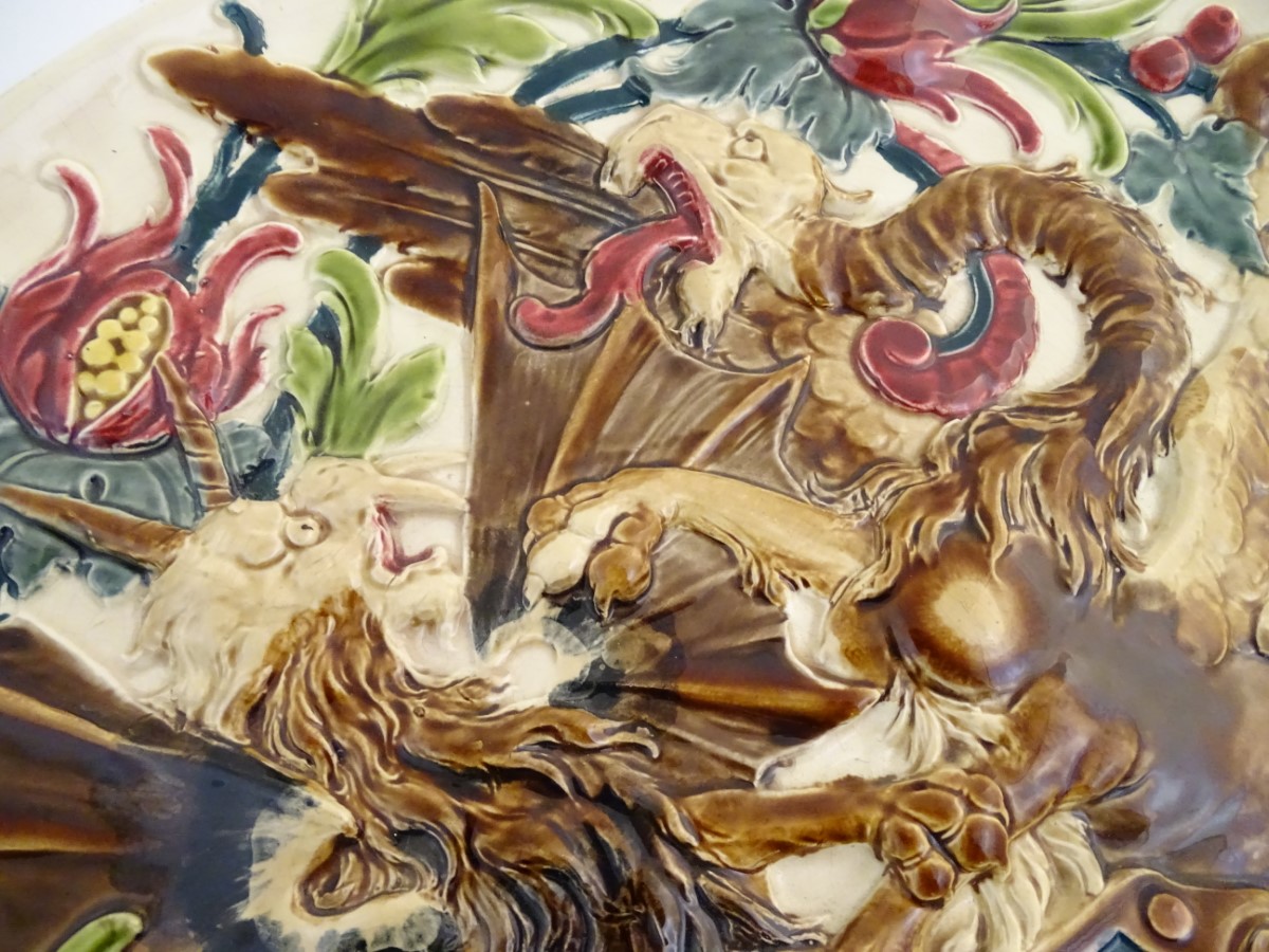 A large 19thC Austrian charger decorated in relief with two fighting griffins / dragons with a - Image 6 of 8