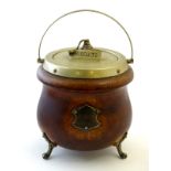 A late 19thC / early 20thC oak biscuit barrel of cauldron form raised on three feet with silver