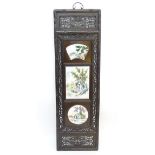 A Chinese panel with three ceramic tiles in a linear setting,