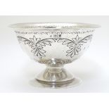 A silver pedestal bowl with embossed decoration.