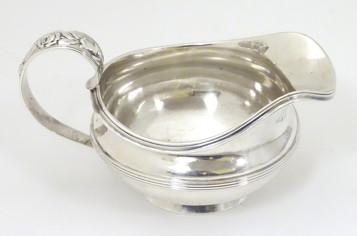 A silver jug / sauce boat with floral decoration to handle hallmarked London 1826 maker William - Image 3 of 8