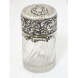 A cut glass jar / scent / perfume bottle with Continental silver mounts and lid with floral and