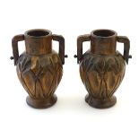 A pair of late 19th / early 20thC treen carved and turned vases with twin handles,