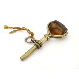 A Victorian gilt metal picket watch key having rotating facet cut seal to handle.