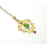 A 9ct gold Art Nouveau pendant set with red white and green stones on an 18" long chain