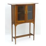 An Arts and Crafts Glasgow school cabinet with an overhanging top,