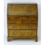 An early / mid 18thC walnut bureau with a fall front and inlaid satinwood stringing,