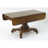 A mid 19thC mahogany centre table with drop flaps, carved ends and unusual carved sides,