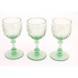 Three green glass pedestal wine glasses with engraved armorial depicting a bull and titled with