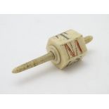 A 19thC bone six sided teetotum / spinning top, marked with the letters NA, LS, ND, SZ, NH, and T.