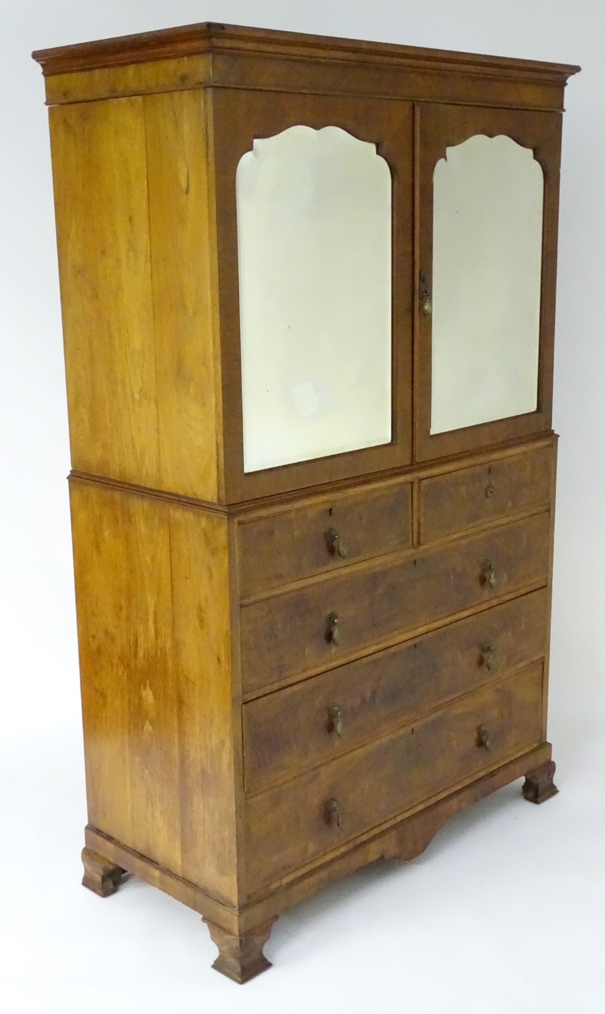 An early 20thC Maple & Co linen press with a moulded cornice above two shaped bevelled edged