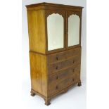 An early 20thC Maple & Co linen press with a moulded cornice above two shaped bevelled edged