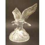 A 20thC glass figure formed as a landing eagle, clutching a salmon upon a domed frosted base.