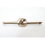 A 9ct gold bar brooch with thistle decoration to centre set with pink tourmaline.