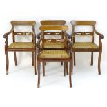 A set of four padouk wood open armchairs with curved top rails and carved mid rails above caned