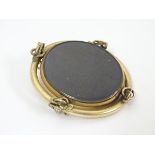 A Victorian gilt metal brooch with central oval rotating locket section 2" high