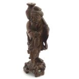 An Oriental carved wooden figure, depicting a fisherman holding a fish and basket. Approx.