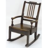 A late 18thC fruitwood rocking chair with unusual turned top rail, slatted backrest,