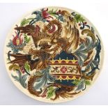 A large 19thC Austrian charger decorated in relief with two fighting griffins / dragons with a