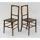 An pair of early 20thC beech chairs with shaped top rails and shell decorated seats above turned