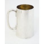 A white metal mug with loop handle 41/2" high.