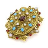 A gilt metal brooch set with moonstone turquoise and red stone cabochon.