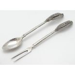 A Continental white metal fork and spoon with filigree decoration to handles.