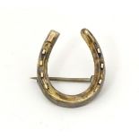 A gold brooch of horseshoe form 1" high CONDITION: Please Note - we do not make