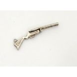 A white metal charm formed as a shotgun 1 3/4" long CONDITION: Please Note - we