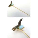 An early 20thC gold stick pin surmounted by a mallard duck, the body formed as an opal,