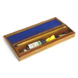 A walnut cased 12 bore shotgun cleaning kit, comprising two-piece wooden rod, woolen mop,
