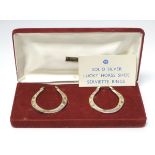 A pair of novelty silver napkin rings formed as 'Lucky Horse Shoes' hallmarked Sheffield 1981 maker