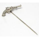 A white metal stick pin decorated with a revolver.