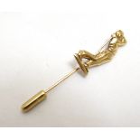 A gilt metal stick pin surmounted by a golfer CONDITION: Please Note - we do not