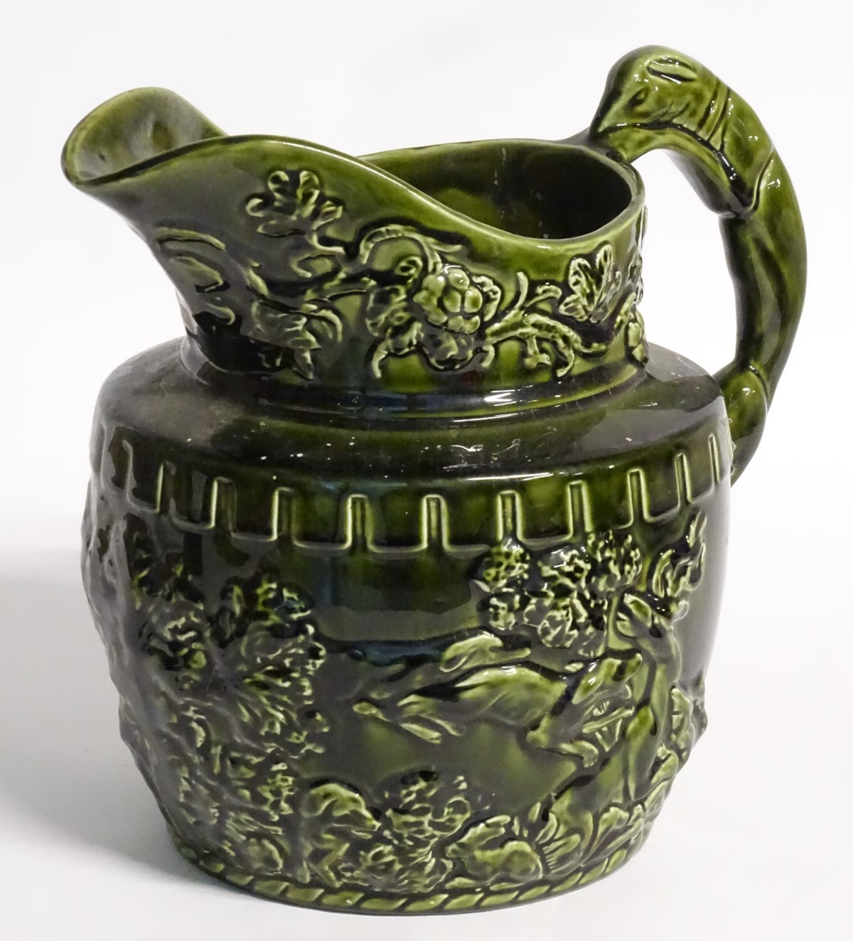 A 20thC Arthur Wood jug / pitcher, decorated with moulded hunting scenes and scrolling foliage,