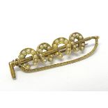 An early 20thC gold brooch formed as a riding whip/crop with four horseshoes having seed pearl