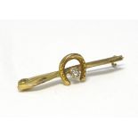A 9ct gold bar brooch with horse shoe decoration and central white stone 1 1/4" wide