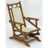A late 19thC / early 20thC walnut childs rocking chair with a ring turned frame and sleigh style