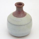 A small two-tone studio pottery bottle vase by Phil Rogers with an ash / nuka glaze.