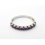 A 9ct gold ring set with 9 amethysts in a linear setting. Ring size approx.