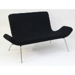 A late 20thC gondola settee with a black upholstered seat and backrest,