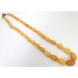 A vintage necklace of graduated butterscotch amber coloured beads. The largest bead 3/4" wide.
