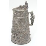 A 19thC silver plate stein with cast decoration end engraved armorial to hinge of lid.