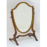 An early 20thC mahogany skeleton mirror with a shield shaped frame.