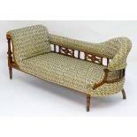An Edwardian rosewood chaise lounge with a pierced fretwork backrest and floral marquetry decorated