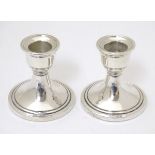 A pair of silver candlesticks hallmarked Birmingham 1962 maker Sanders & Mackenzie 2 1/2" high