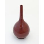 A Chinese globular vase with a slender, elongated neck with a sang de boeuf glaze. Approx.