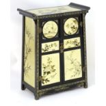 A 20thC oriental cabinet with panelled doors and pen work decoration.